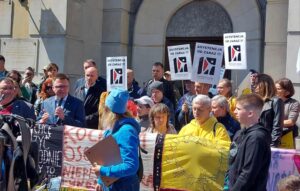 Członkowie Stowarzyszenia Otwarte Drzwi stojący razem podczas protestu w Warszawie.